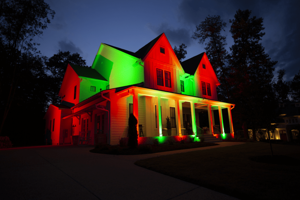 Photo of a house lit up in green and red on the exterior.