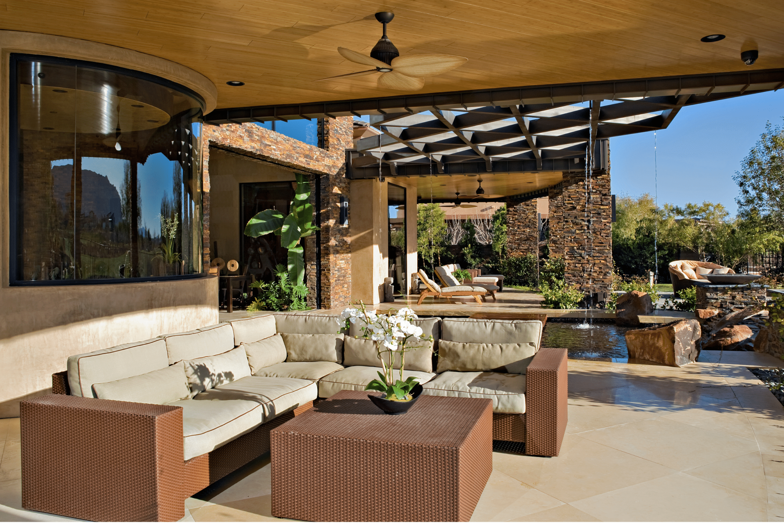 This is an image of a patio with a fountain and a sofa and chairs.