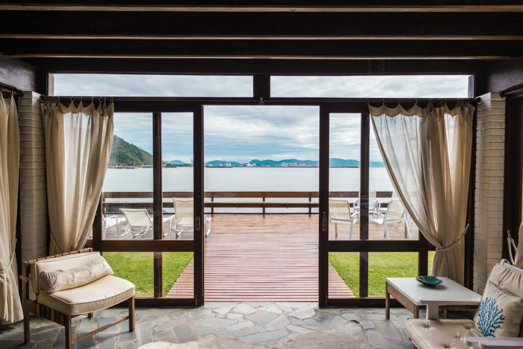 Photo of a luxury home with windows open overlooking a body of water.