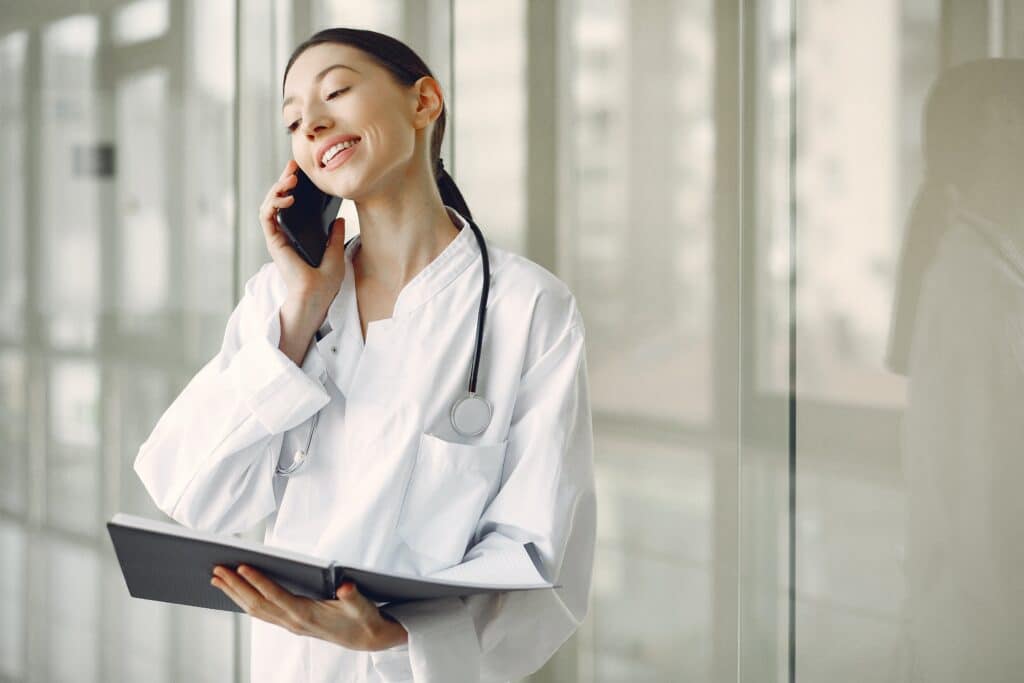 Photo with a doctor holding an ipad and talking on the phone.