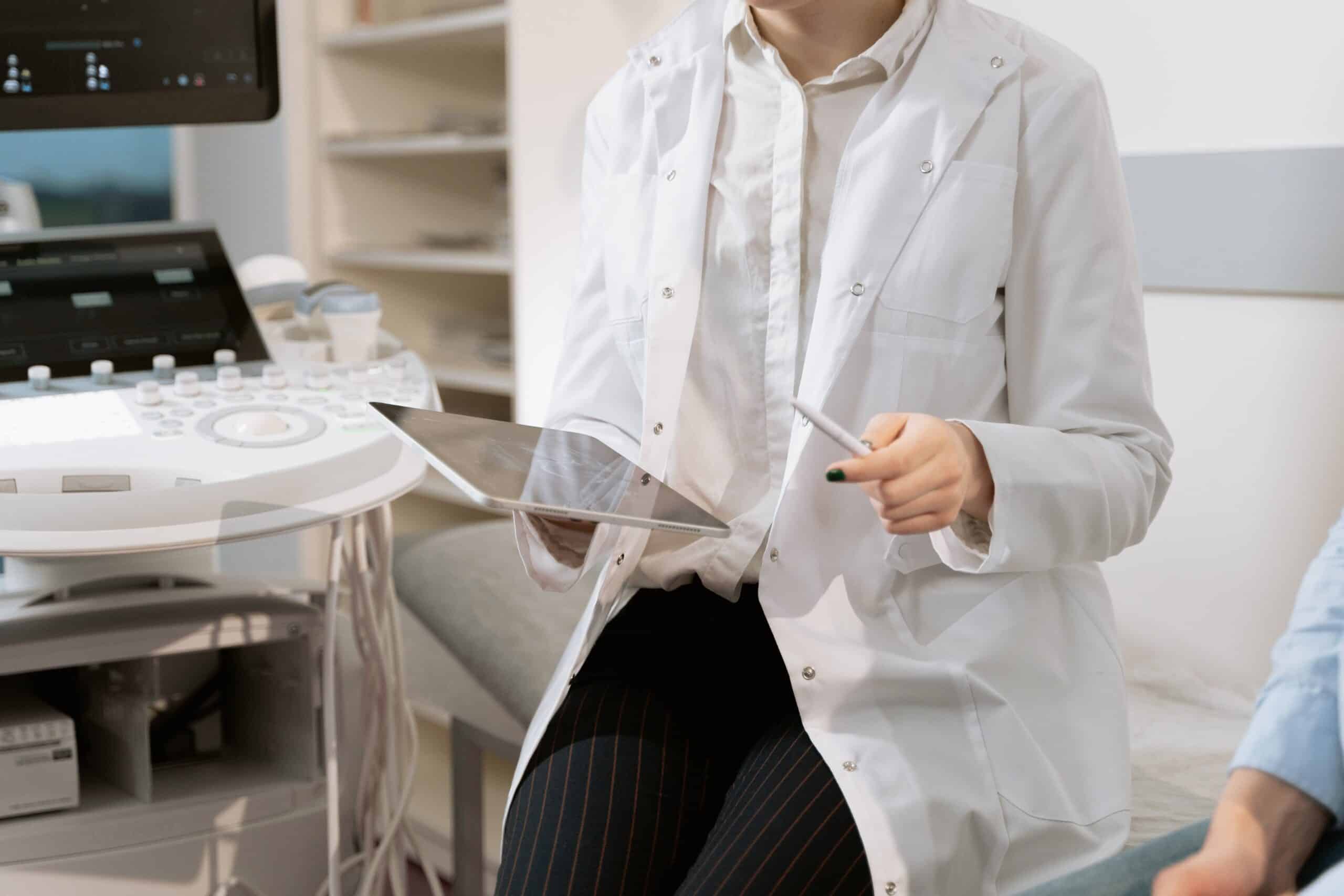 Torso shot of a medical practitioner with a tablet in her hand.